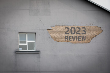 2023 Review Concept. The plaster has fallen off the wall of the house - obrazy, fototapety, plakaty
