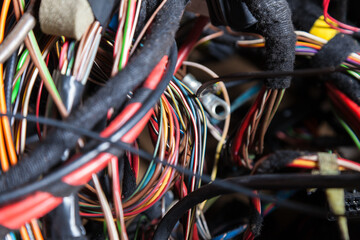 A cable of matted wires of different colors with connectors in the electrical wiring of the car....