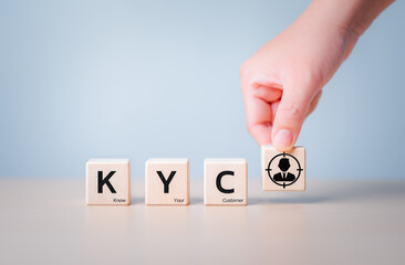 Know Your Customer - KYC letters on wooden cubes with hand holding magnifying glass icon on block....