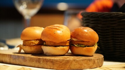 Close-up shot of mini burgers on a wooden board