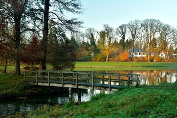 Le petit pont en bois reliant une ile à l'un des étangs du parc de Tervuren en fin de journée d'automne 
