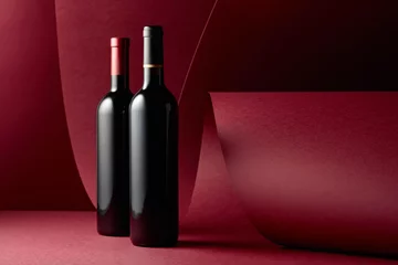 Gordijnen Bottles of red wine on a red background. © Igor Normann