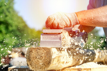 a carpenter works with an electric pipe on a sunny day