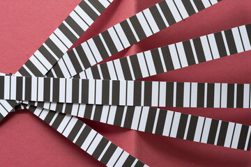 set of paper stripes with black and white lines arranged layered on folded rough paper