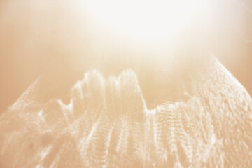 White shiny glare from sunlight on beige background, abstract nature photo with sunshine flare,...