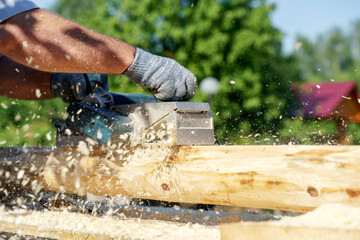 a carpenter works with an electric pipe on a sunny day