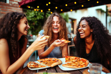 Three happy female friends eating pizza in restaurant - obrazy, fototapety, plakaty