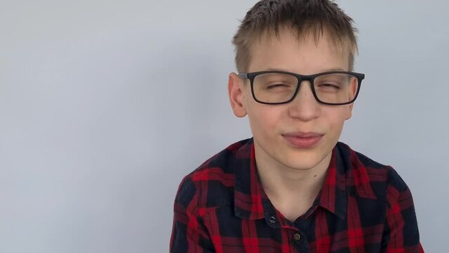 Guy is teenager and poor eyesight. Handsome guy in vision glasses squints