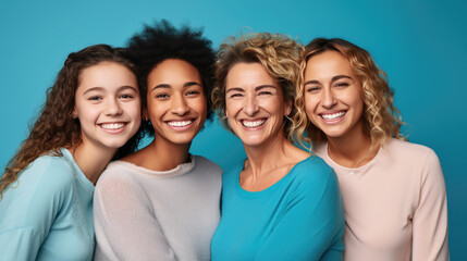 Four happy women of different ages and ethnic backgrounds, with bright smiles, posing together against a vibrant blue background.