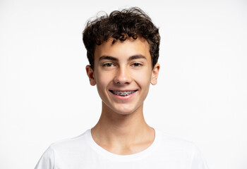 Portrait attractive smiling teenage boy with braces looking at camera, isolated on white background