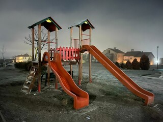 Beautiful shot of two slides in a playground on a foggy day