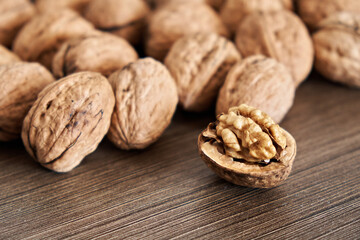 Peeled walnut kernels on a background of whole nuts. Up close