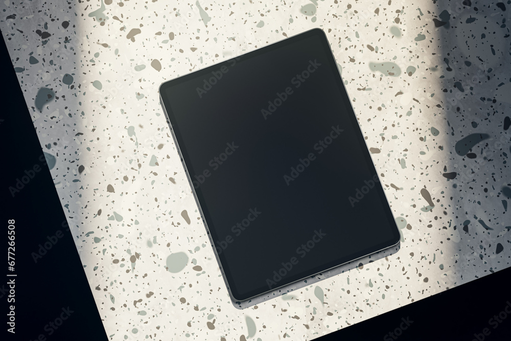 Aufkleber Top view of empty black tablet on spotted table. Mock up, 3D Rendering.