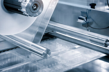 Automatic polyethylene plastic bag production machine with lighting effect. Close-up of the roller...