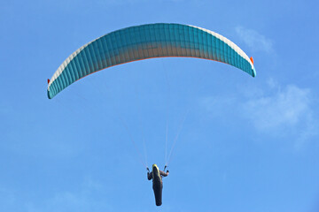 Paraglider flying in a blue sky
