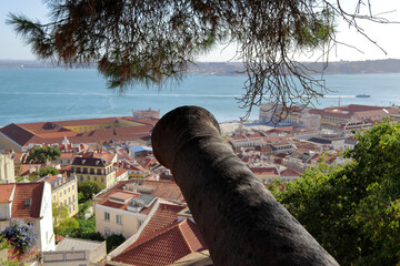 View of Lisbon from the hill of Saint George Castle (Castelo De Sao Jorge) with an old cannon in...