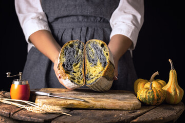 sourdough activated charcoal black bread with pumpkin turmeric and housewife woman baker rustic...