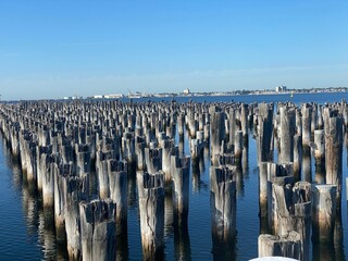 High angle shot of wooden pier poles on blue water