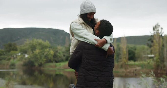 Couple, man lifting woman with hug and happiness outdoor, love and commitment, trust and safety together. Bonding, support and care, man and woman on date in nature park with happy youth in forest