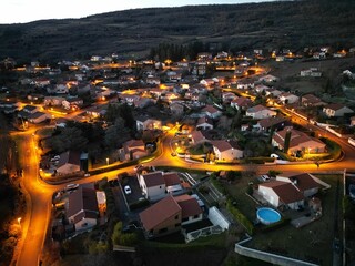 Aerial view of a village and mountain landscape during dusk