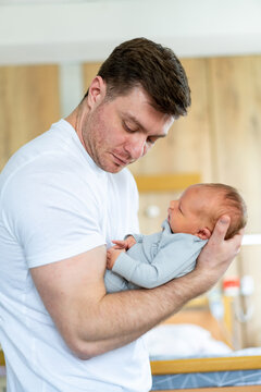 Lovely father with newborn baby. Small baby holding on hands.