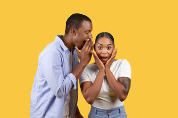 Black man whispers to surprised woman - obrazy, fototapety, plakaty