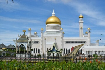 Exterior view of Omar Ali Saifuddien Mosque, Brunei, with a golden-domed roof and a metallic fence