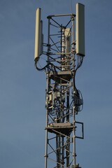 Fototapeta na wymiar Vertical shot of a wireless communication antenna against a blue sky