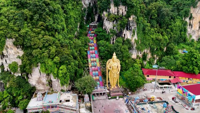 Aerial 4K footage of Lord Murugan statue at the entrance of Batu Caves with colorful steps in Kuala Lumpur, Malaysia. It's one of the most important Hindu shrines outside of India