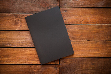 Closed notebook on a rustic wooden board