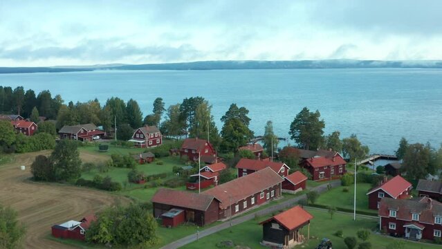 Swedish village red house drone shot. Aerial view of lake typical wooden cabins