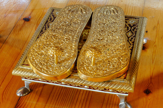 Gold slippers/flip flops on a stand at a Hare Krishna temple