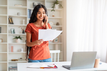 Energetic Millennial Eastern Woman Balancing Calls and Paper Work