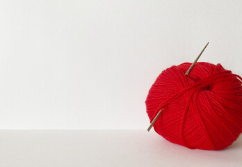 A skein of red yarn for hand knitting on a white background. Empty space for text, close-up, mockup - obrazy, fototapety, plakaty