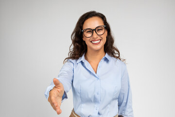 Smiling pretty young caucasian woman manager in formal, glasses make shake hands for say hello