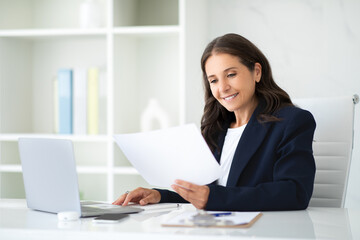 Positive mature businesswoman working at modern office
