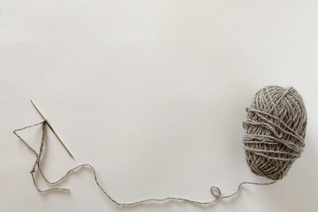 Woolen ball of yarn and hook on a white background. Copy space, top view