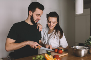 male and female discussing healthy food while cooking at home counter top