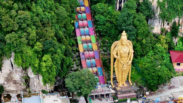 Aerial 4K footage of Lord Murugan statue at the entrance of Batu Caves with colorful steps in Kuala Lumpur, Malaysia. It's one of the most important Hindu shrines outside of India