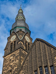 Obraz premium the steeple of the protestant church with two clocks in ratingen homberg in the sunlight