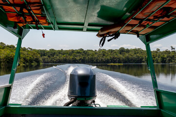 Inside view of a speedboat with its motor creating a wake on a river in the Amazon region