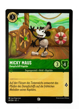 Hamburg, Germany - 10312023: macro photo of the German Ravensburger trading card Mickey Mouse Steamboat Pilot from the Disney lorcana The first chapter set on white paper background.