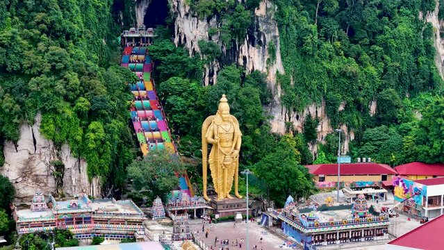 Aerial 4K footage of Lord Murugan statue at the entrance of Batu Caves with colorful steps in Kuala Lumpur, Malaysia. It's one of the most important Hindu shrines outside of India