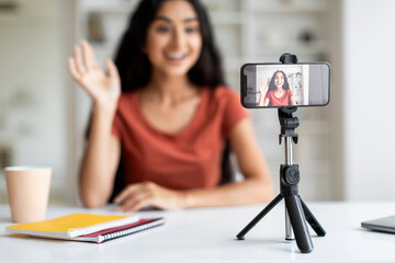 Phone on tripod recording young indian woman blogger