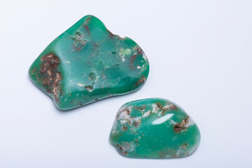 Studio close up photo of two tumbled chrysoprase stones on white background