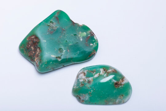 Studio close up photo of two tumbled chrysoprase stones on white background