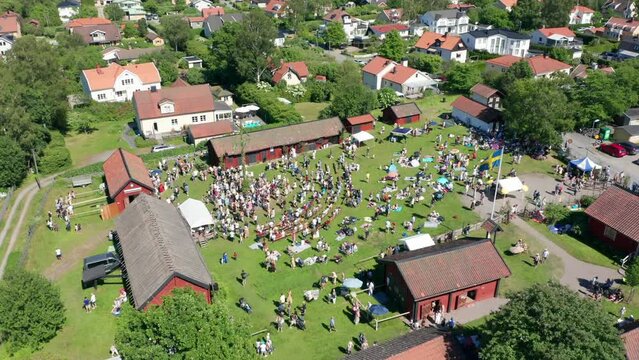 Swedish midsummer celebration in Sweden. People or crowd dancing around pole