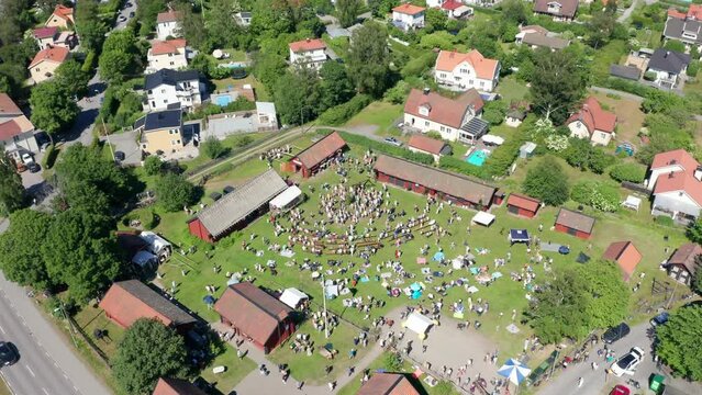 Swedish people dancing around midsummer pole on celebration day