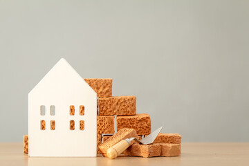Home model and brick put on the desk in the office, Loan for real estate or construction industry a...