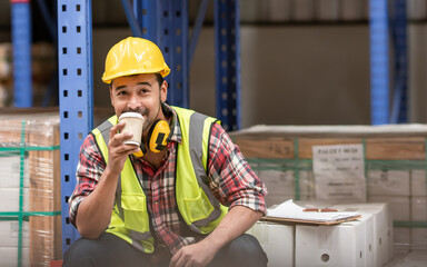 Asian handsome professional male worker smiling, holding cup of coffee, taking rest after work in...